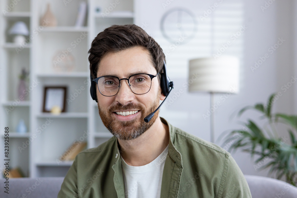 Smiling man with headset engaged in a virtual meeting from his modern home office. Business and technology concept. Smiling man with headset engaged in a virtual meeting from his modern home office. Business and technology concept.