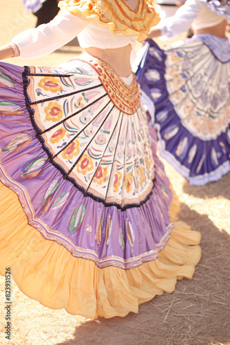 Close-up of traditional Mexican dancers  skirts with colorful embroidery. Outdoor festival celebration concept. Design for poster  print  banner