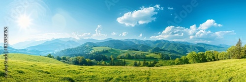 Beautiful panoramic view of green grassy hills with trees and mountains in the background under a blue sky on a sunny day