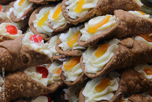 Sicilian cannoli filled with ricotta cheese and with cherry and orange for sale in Sicily photo