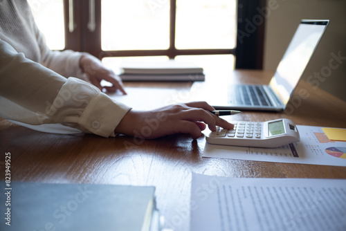 Wallpaper Mural Cropped image of professional businesswoman, entrepreneur or accountant working on a financial report paperwork at her desk, using calculator or laptop. Torontodigital.ca