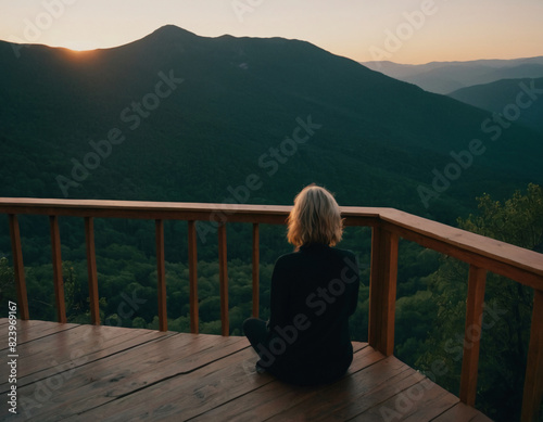 Woman Enjoying Mountain Sunset from Wooden Deck