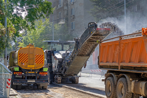 Modern. industrial paving machine removing asphalt outside on urban city street