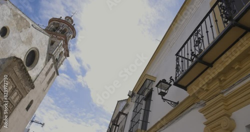 Nuestra senora de la O medieval church tower facade in Sanlucar de Barrameda on a sunny day with blue sky panning right to left photo