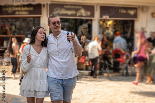 Young couple tourists walking in the ancient European city center. Explorers have trip to monument ancient landmark historical building castle. Vacation family. Traveling holidays Vertical