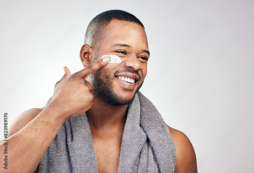 Obraz premium Black man, face cream and smile in studio for beauty with application, cosmetics and pride by mockup. Male model, hand and skincare treatment with lotion, moisturizer and results by white background