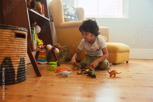 Cute young boy playing with colourful animal toys. at home photo