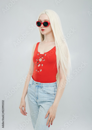 a beautiful woman in a red top and sunglasses on a white background