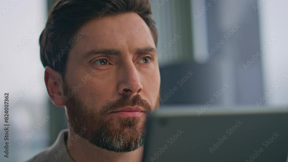 Bearded man looking tablet reading message in morning flat closeup. Relaxed guy Bearded man looking tablet reading message in morning flat closeup. Relaxed guy