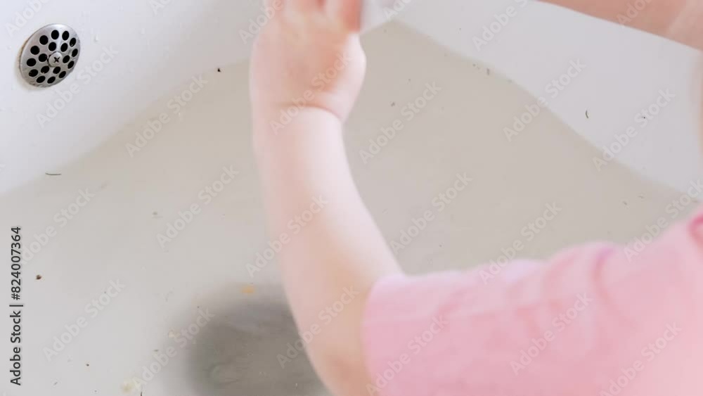 closeup children's hands washing dishes in porcelain sink in kitchen ...