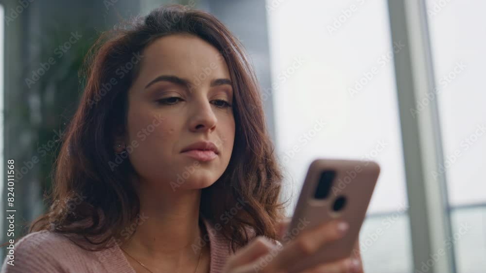 Serious lady typing sms smartphone at kitchen closeup. Brunette looking cell Serious lady typing sms smartphone at kitchen closeup. Brunette looking cell