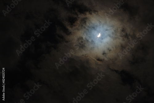Near total eclipse of the Sun. The moon covers the sun in a solar eclipse and cloudy dramatic sky. Nature phenomenon. 