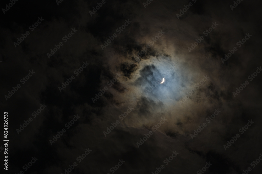 Near total eclipse of the Sun. The moon covers the sun in a solar eclipse and cloudy dramatic sky. Nature phenomenon. Near total eclipse of the Sun. The moon covers the sun in a solar eclipse and cloudy dramatic sky. Nature phenomenon.