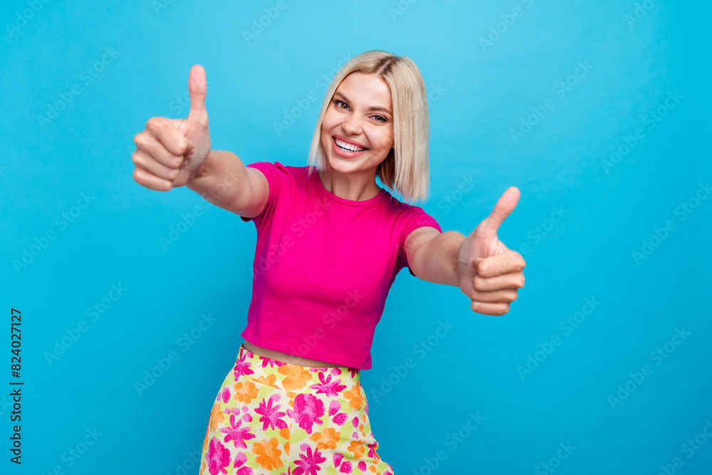Photo portrait of lovely young lady show thumbs up dressed stylish pink clothes isolated on blue color background Photo portrait of lovely young lady show thumbs up dressed stylish pink clothes isolated on blue color background