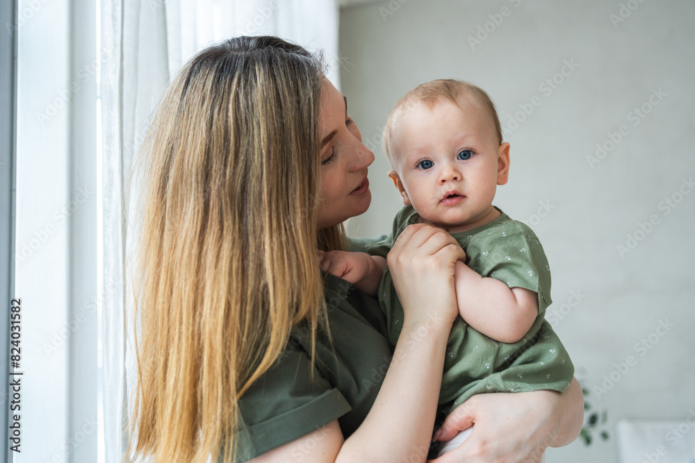 Happy family at home. Mother holding little toddler child daughter. Mom and baby girl relax playing having fun together at home. Mother hugging kissing baby with love care. Mom of breast feeding baby Happy family at home. Mother holding little toddler child daughter. Mom and baby girl relax playing having fun together at home. Mother hugging kissing baby with love care. Mom of breast feeding baby
