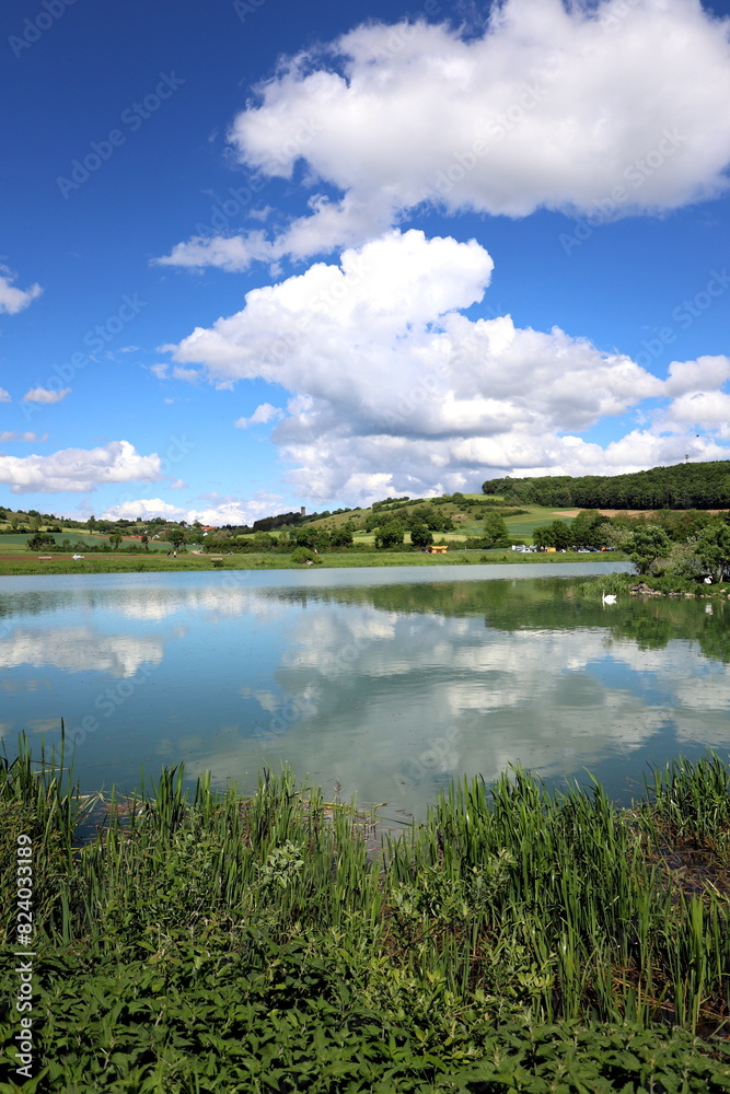 Wolken spiegeln sich im Härtsfeldsee in Dischingen
