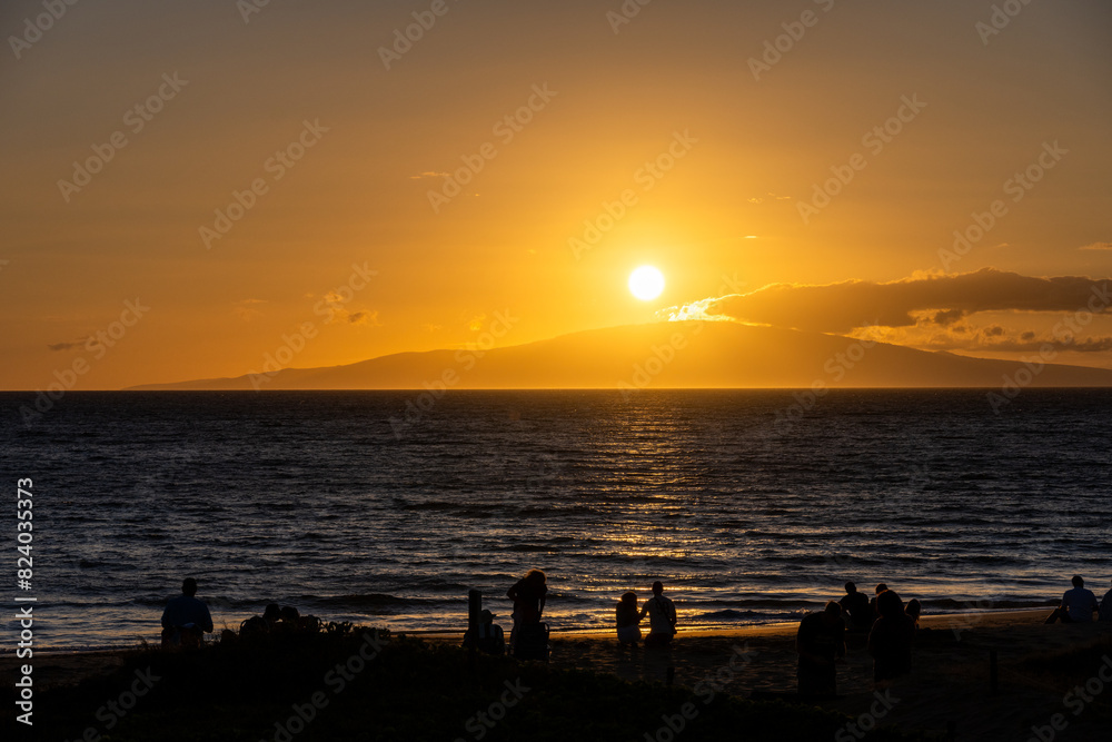 Silhouettes of people watching the warm sunset over the Pacific Ocean from the beach at Kihei, Maui, Hawaii, as a nature background
Silhouettes of people watching the warm sunset over the Pacific Ocean from the beach at Kihei, Maui, Hawaii, as a nature background