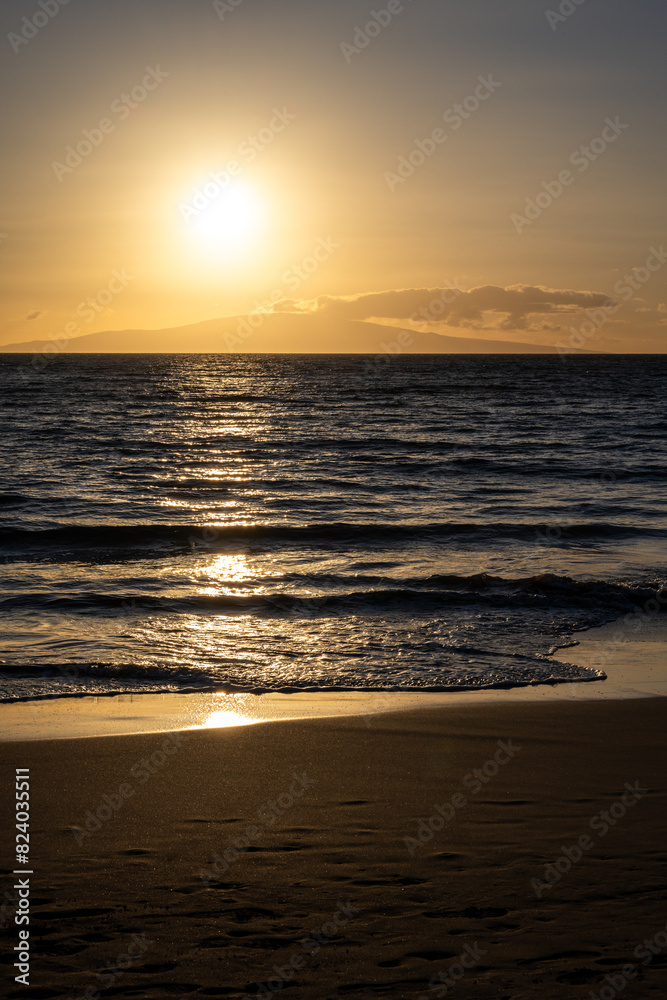 Naklejka premium Warm sunset over the Pacific Ocean from the beach at Kihei, Maui, Hawaii, as a nature background 