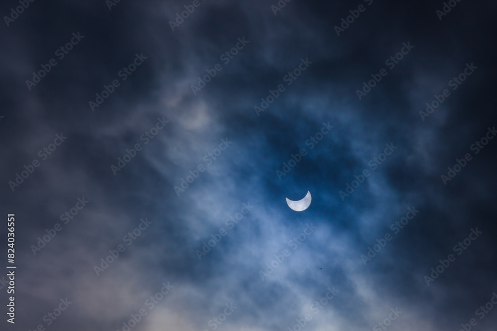 Near total eclipse of the Sun. The moon covers the sun in a solar eclipse and cloudy dramatic sky. Nature phenomenon. Near total eclipse of the Sun. The moon covers the sun in a solar eclipse and cloudy dramatic sky. Nature phenomenon.