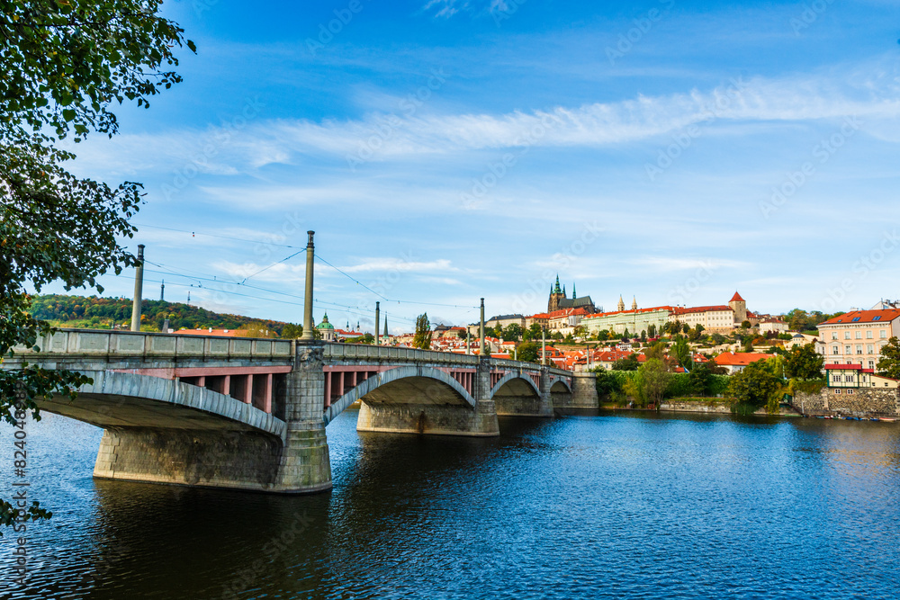 Fototapeta premium Prague, Czech Republic: Manes Bridge and the castle complex of Prague viewed from the banks of river Vltava