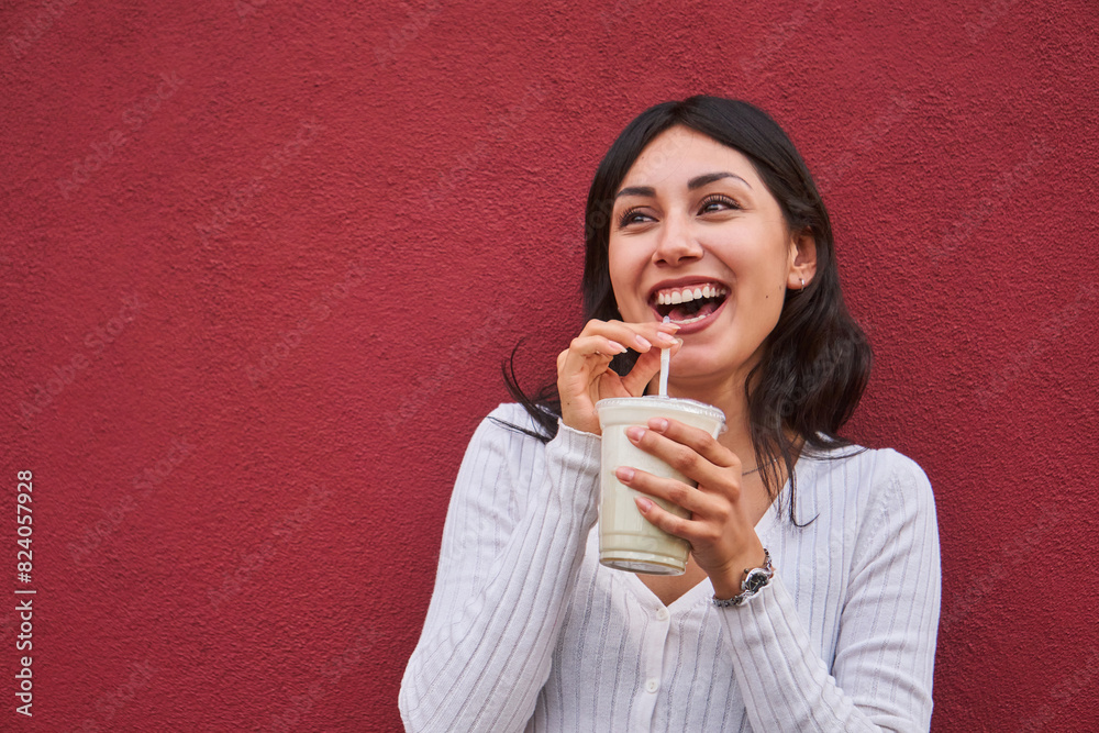 Joyful young woman enjoying a drink outdoors Joyful young woman enjoying a drink outdoors