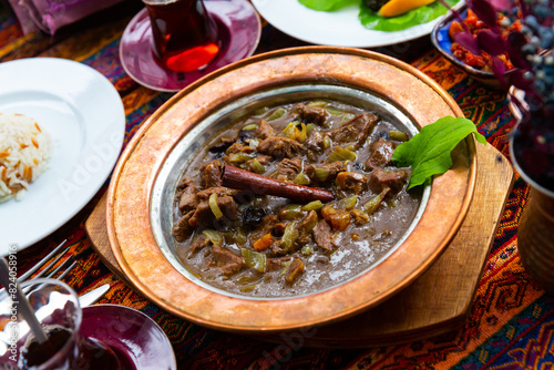 Mutancana, a turkish meal with lamb meat, prunes and vegetables photo