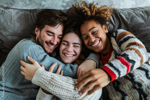 A happy polyamorous triad cuddling together on the couch, their arms intertwined in a loving embrace as they share stories and laughter. Concept of polyamorous love and connection. Generative Ai. photo