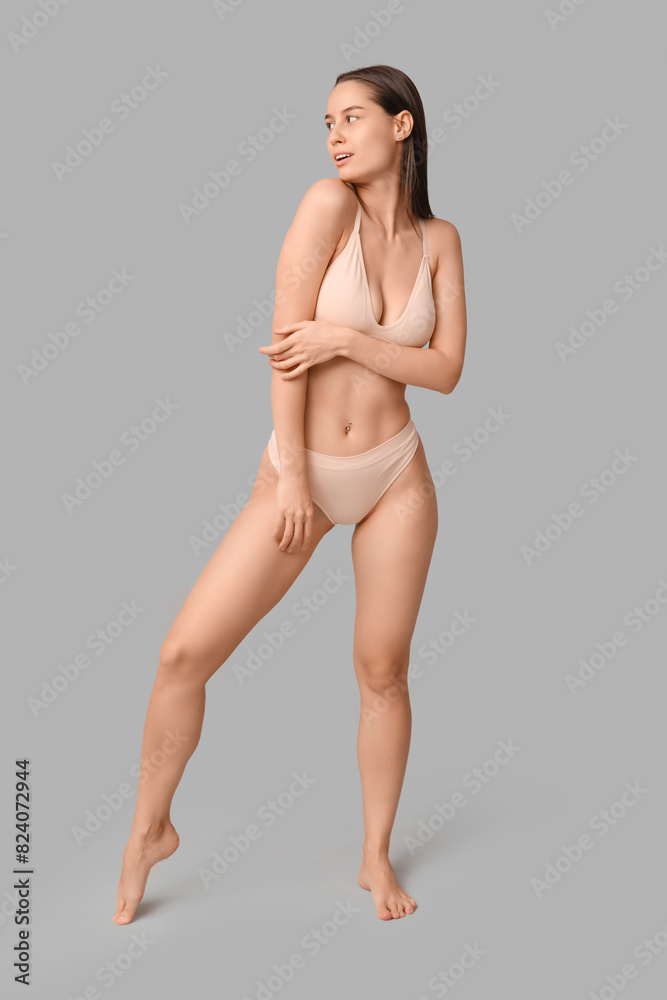 Naklejka premium Beautiful young woman in light underwear on white background