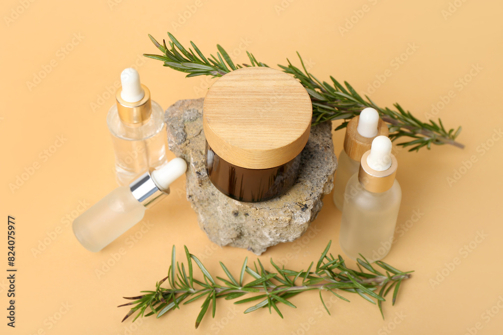 Composition with bottles of cosmetic products, rosemary, jar and stone on color background Composition with bottles of cosmetic products, rosemary, jar and stone on color background