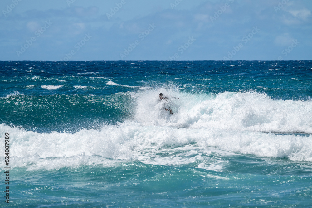 Surfer in the splashing waves of the Pacific Ocean off the coast of Maui at Hookipa Beach, active tropical vacation in paradise, Hawaii
Surfer in the splashing waves of the Pacific Ocean off the coast of Maui at Hookipa Beach, active tropical vacation in paradise, Hawaii
