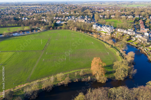 Aerial photo of the town centre of Wetherby in West Yorkshire in the UK, showing the River Wharfe at the side of soccer football pitches and houses on the other side on a sunny day in the winter photo