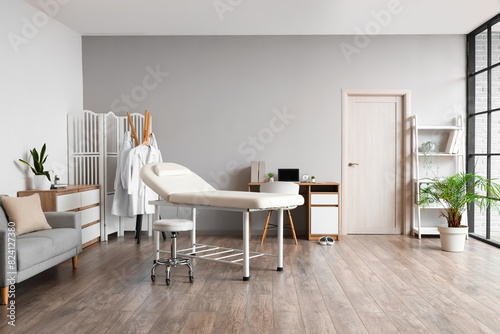Interior of medical office with couch, sofa and doctor's workplace