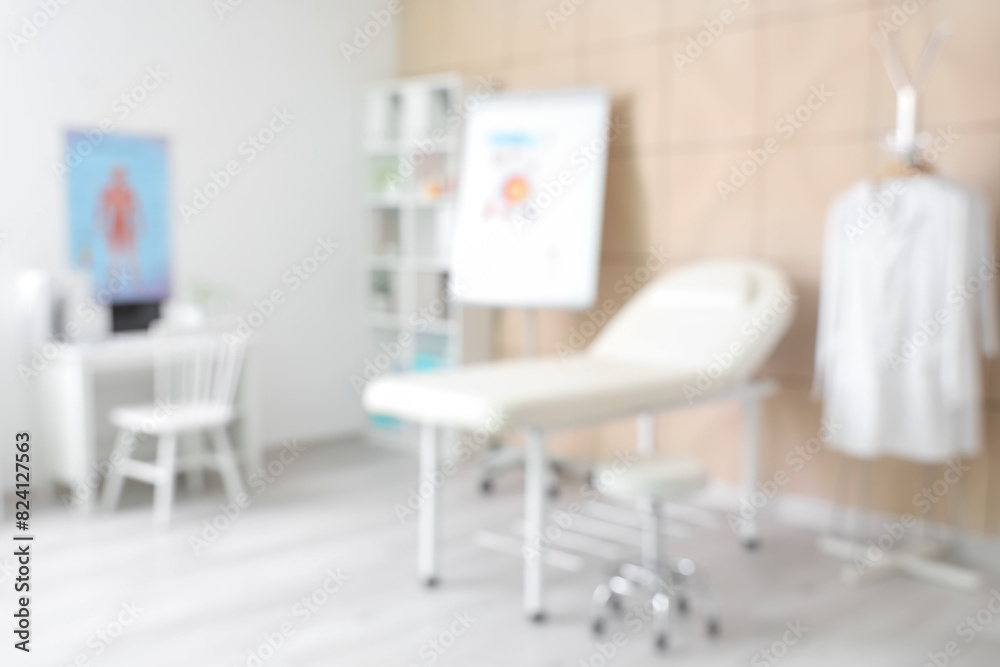 Fototapeta premium Blurred view of medical office with couch and doctor's workplace