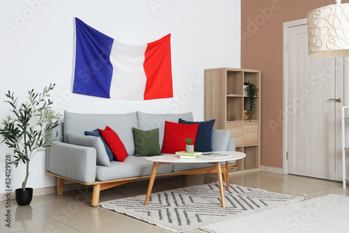Interior of living room with sofa, table and French flag photo