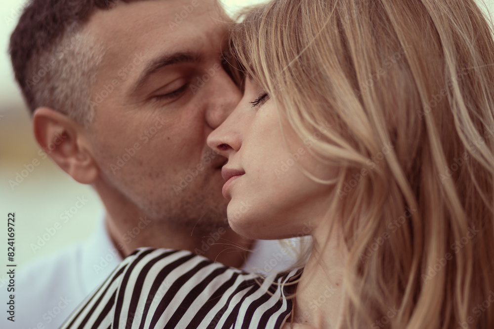 Man kissing woman on the head, hugging her from behind. Man kissing woman on the head, hugging her from behind.