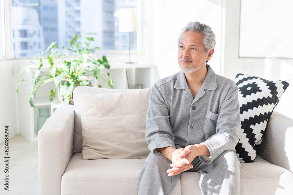 部屋でリラックスするシニア男性 パジャマ 部屋でリラックスするシニア男性 パジャマ