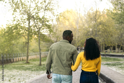 back view of a afro american couple walking in a park