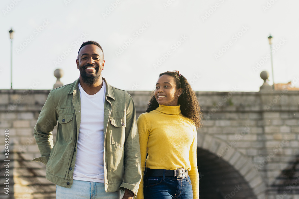 smiling african american couple portrait in front of a bridge smiling african american couple portrait in front of a bridge