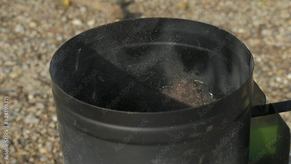 Preparation for grilling. A man's hand throws pieces of black coal ready for burning