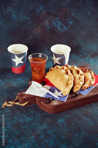 empanadas de pino junto con mote con huesillos junto a vasos con bandera de Chile, fondo celebración fiestas patrias de Chile photo