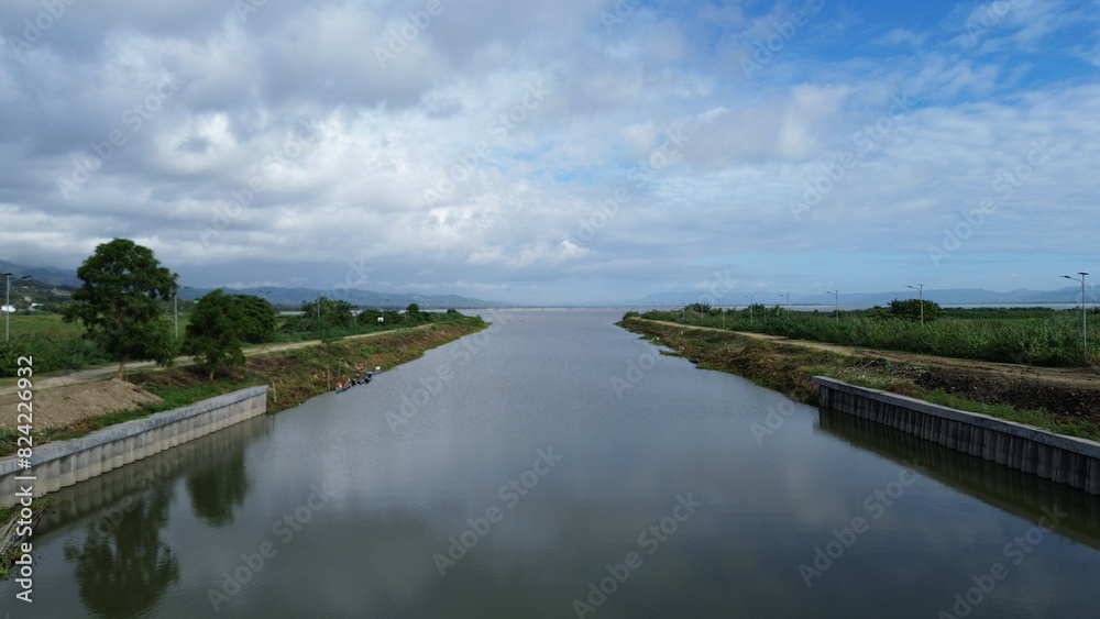 Landscape view of a canal with blue sky and white clouds. Landscape view of a canal with blue sky and white clouds.