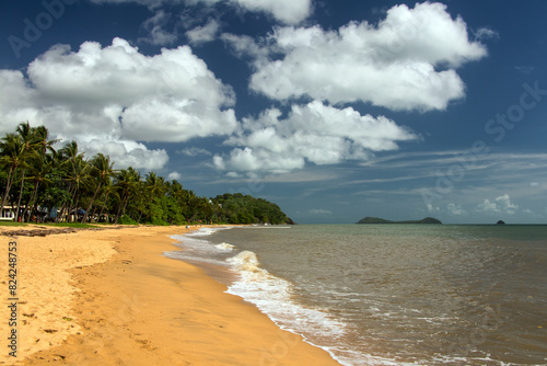 Experience the pristine beauty of Trinity Beach in Far North Queensland  Australia  where golden sands meet azure waters under a tropical sun  inviting relaxation and coastal bliss.