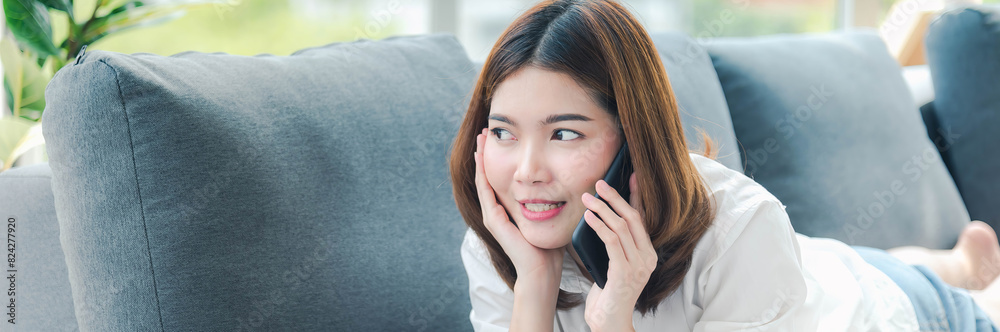Banner Women sitting on sofa using smartphone, credit card to shopping online with smiling face shopaholics. Panorama Happy asian women lay down use smartphone. Woman online shopping with copy space Banner Women sitting on sofa using smartphone, credit card to shopping online with smiling face shopaholics. Panorama Happy asian women lay down use smartphone. Woman online shopping with copy space