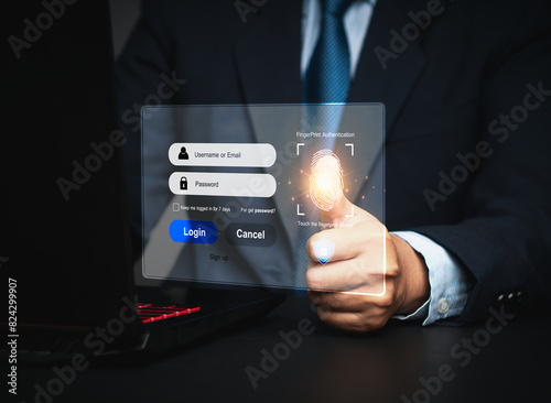Businessman hand touches a fingerprint sensor on a laptop, with a login interface displayed on the virtual screen.