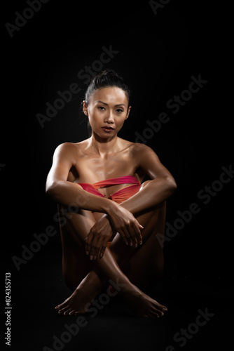 Asian woman wearing a bikini sit posing in studio