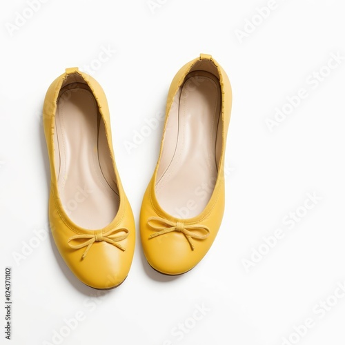 Against a pristine white backdrop, yellow ballet flats radiate a sunny charm, infusing the scene with vibrant energy