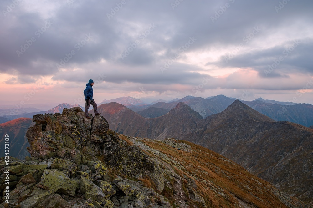 Obraz premium Beautiful mountains at sunset. Man who enjoys a break look at the top of the mountain at sunset adventure travel.