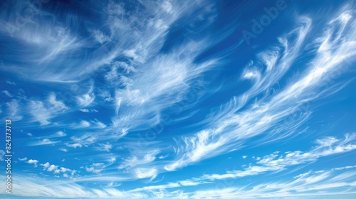 Thin white clouds floating in a rich blue sky photo