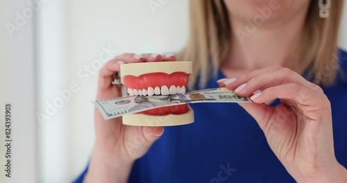 Dentist and hundred dollar bill and artificial jaw photo