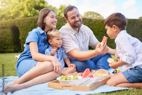 Mother  father and kids picnic in park for weekend bonding  eating and happy family on grass together. Mom  dad and children in garden with healthy food  fruit and smile in backyard for outdoor lunch
